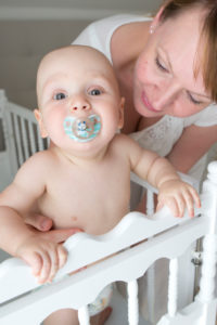 Mutter mit Baby am Gitterbett, Close-up Mutter mit Baby am Gitterbett, Close-up